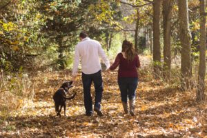 Man and woman walk with dog - Positive Reinforcement Dog Training